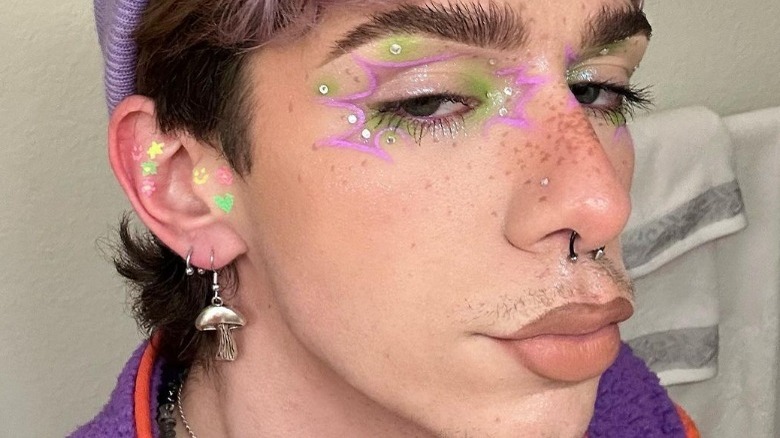 Man models graphic eyeliner featuring negative space