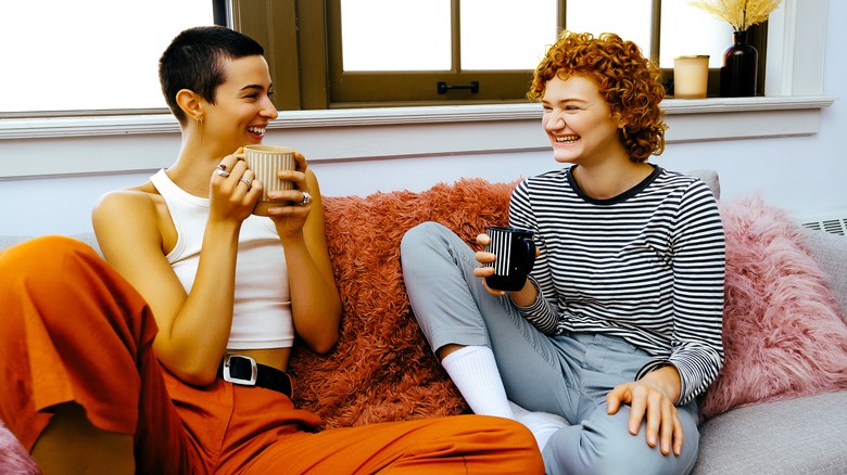 women laughing on sofa