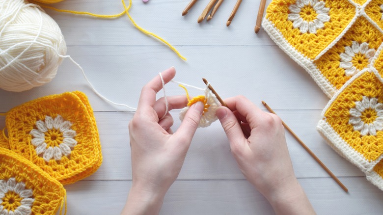 Woman's hands crocheting quilt squares