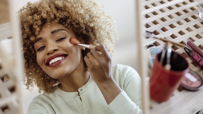 Woman applying blush