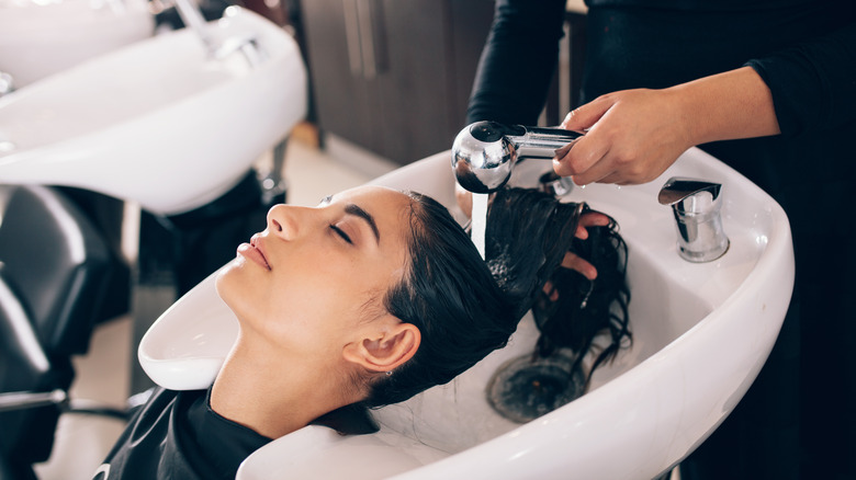 woman having hair rinsed at salon