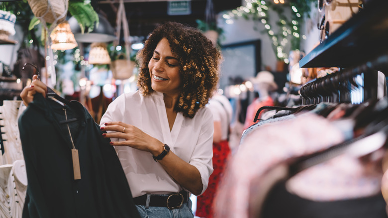 Woman browsing through clothing racks