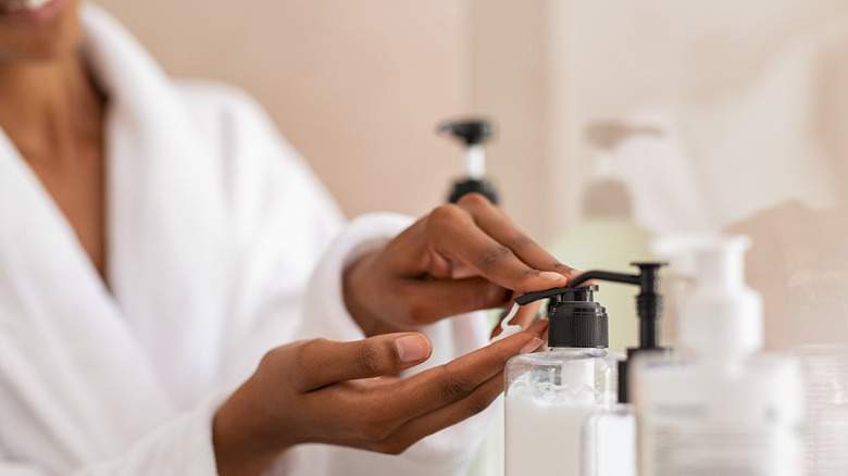 Woman getting lotion from pump bottle