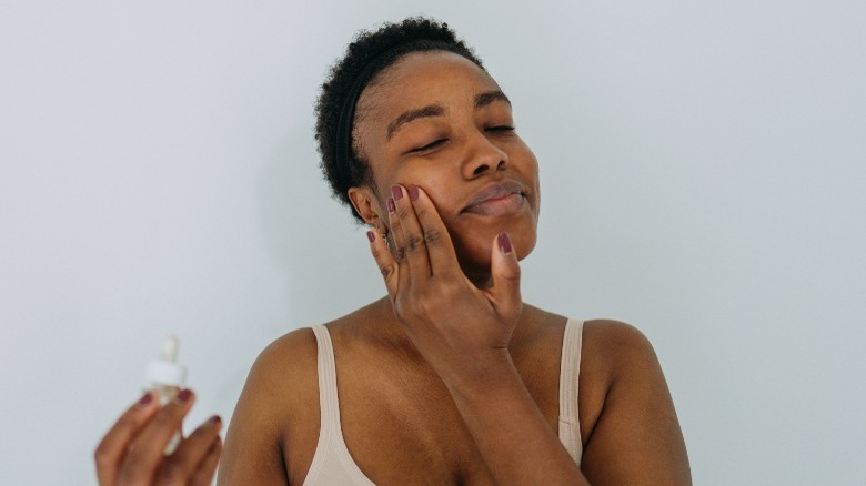 Woman applying makeup primer