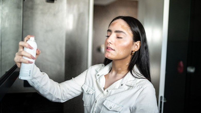 Woman using a makeup setting spray