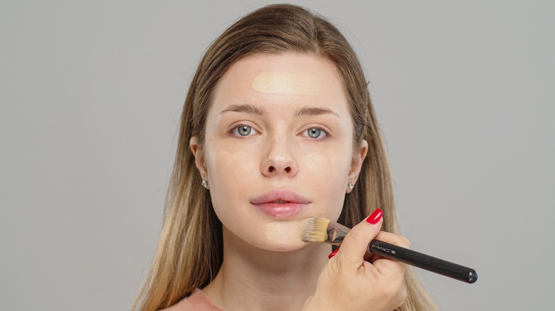 woman applying foundation