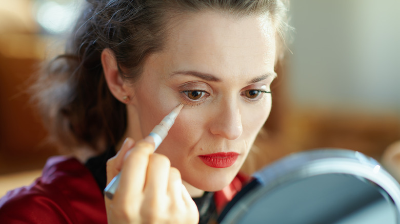 Woman using concealer pen