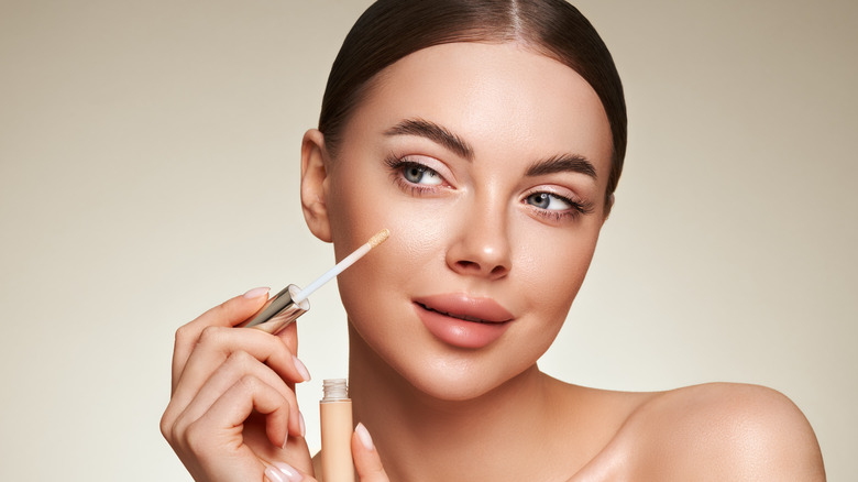 Woman applying concealer