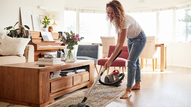 Woman vacuums rug