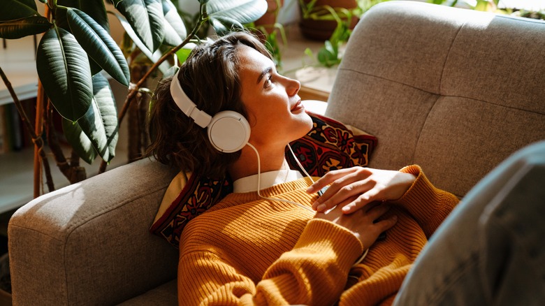 woman on sofa wearing headphones