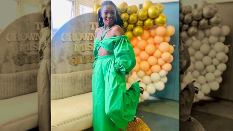 Woman in green jumpsuit posing in front of balloons