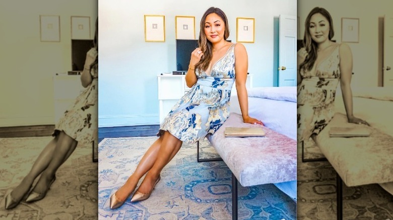 Woman wearing short cocktail dress and sitting on bench