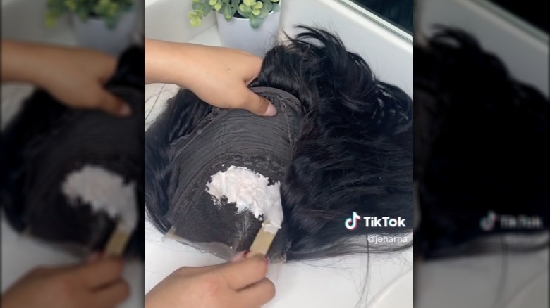 Woman bleaching knots on wig