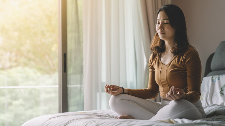 Woman meditating on bed