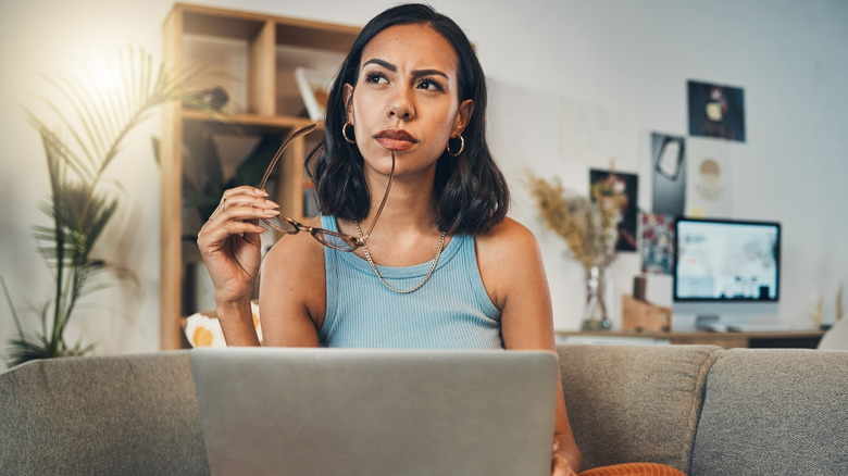 Woman with laptop thinking