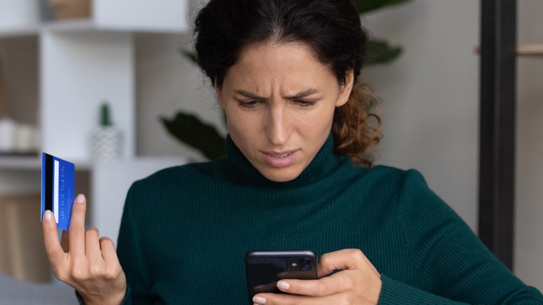 Woman holding credit card and phone