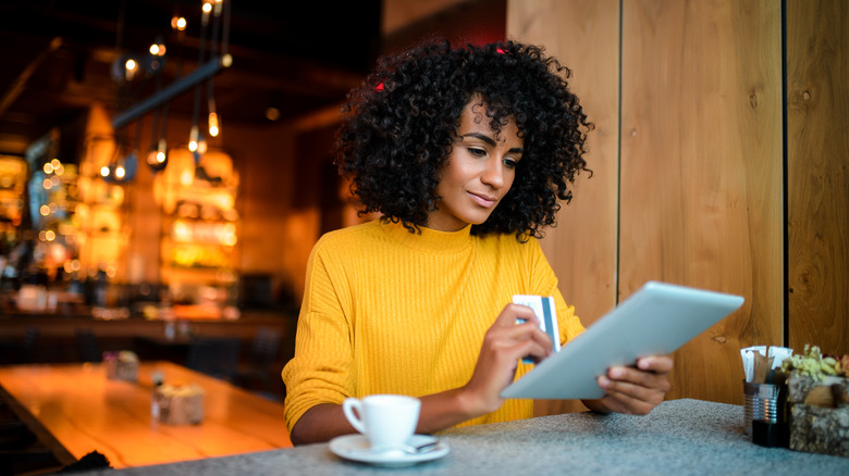 Woman online shopping at cafe