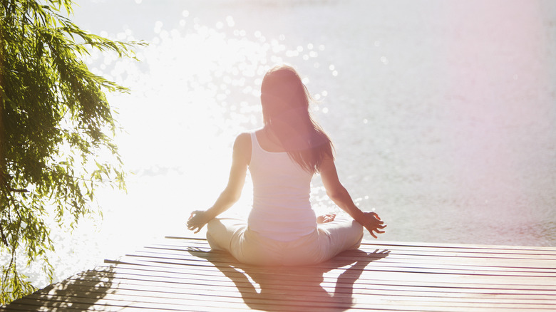 Woman meditating by water