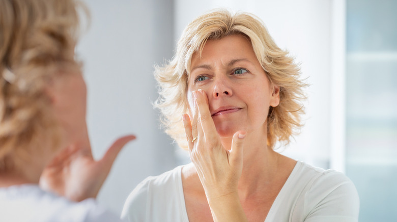 mature woman applying sunscreen