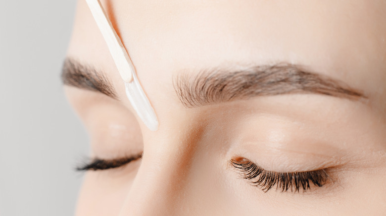 woman waxing her eyebrows 