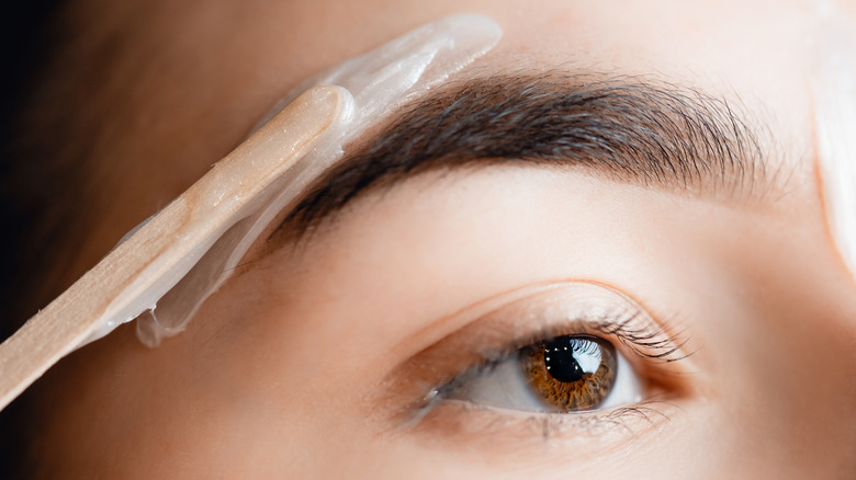 person getting eyebrow waxed