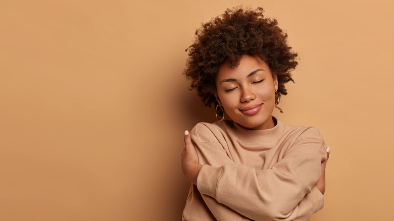 Woman hugging herself