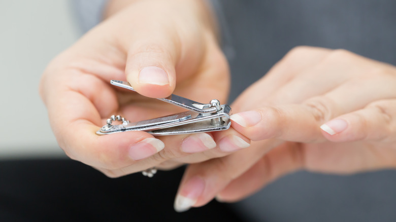 person using nail clippers