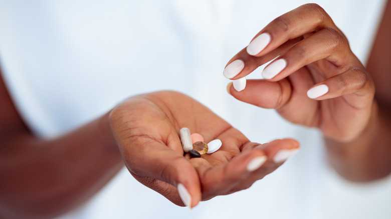 person holding vitamins and supplements