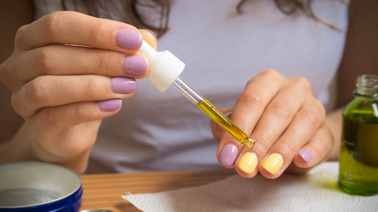 person applying cuticle oil