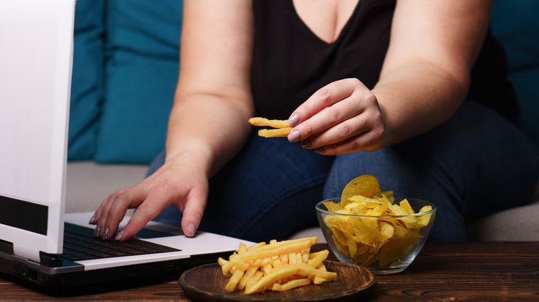 overweight woman eating french fries