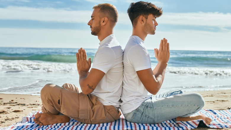 gay couple yoga on beach