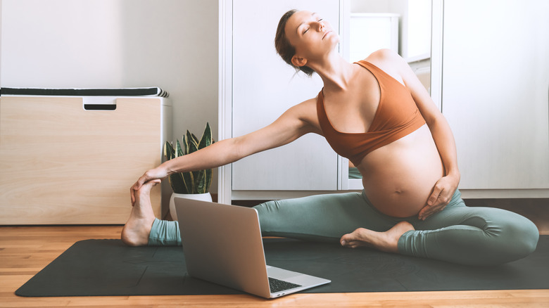 pregnant woman doing virtual yoga
