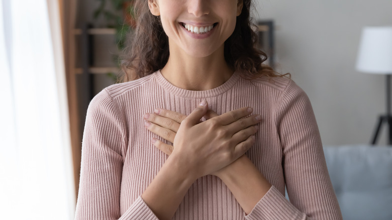 happy woman touching chest