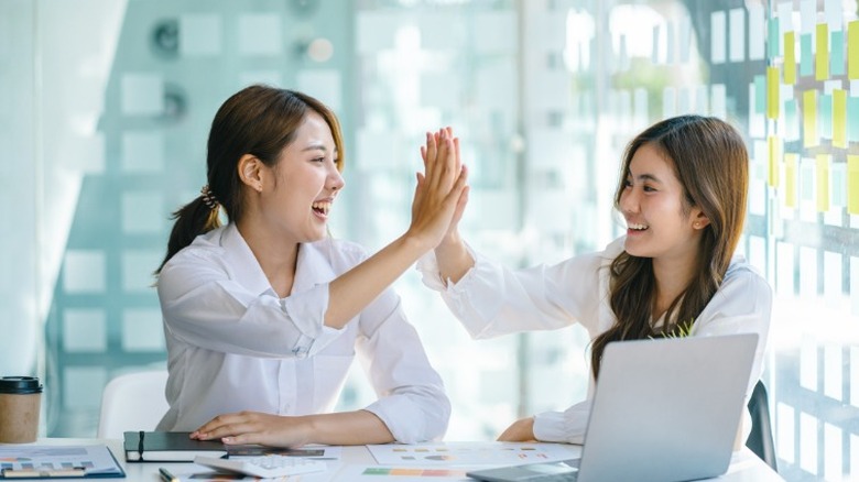 Two women high-fiving 