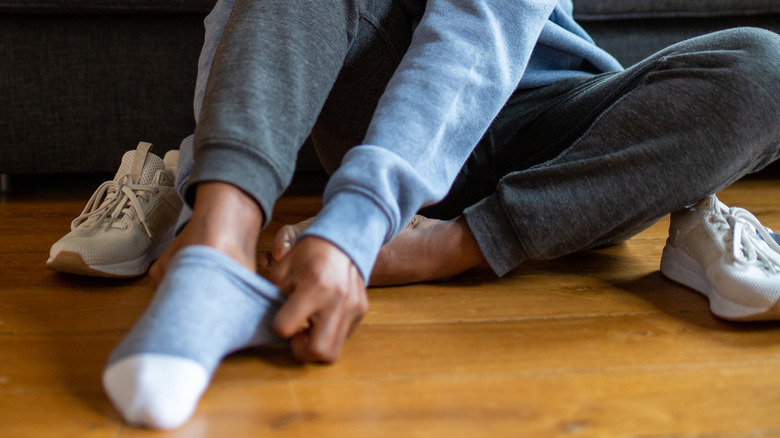 woman putting on socks