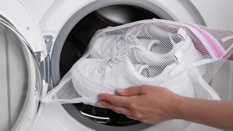 woman putting shoes in washer