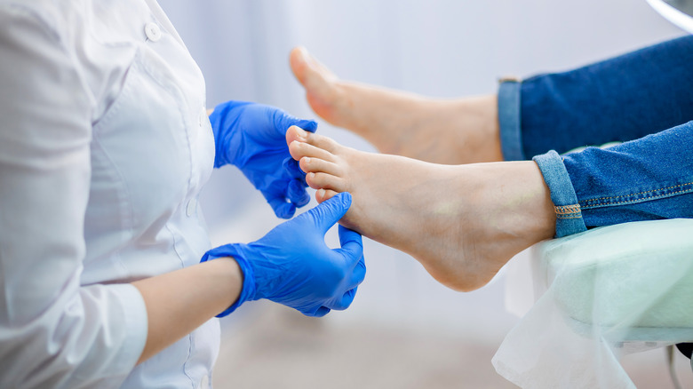 doctor examining foot in office