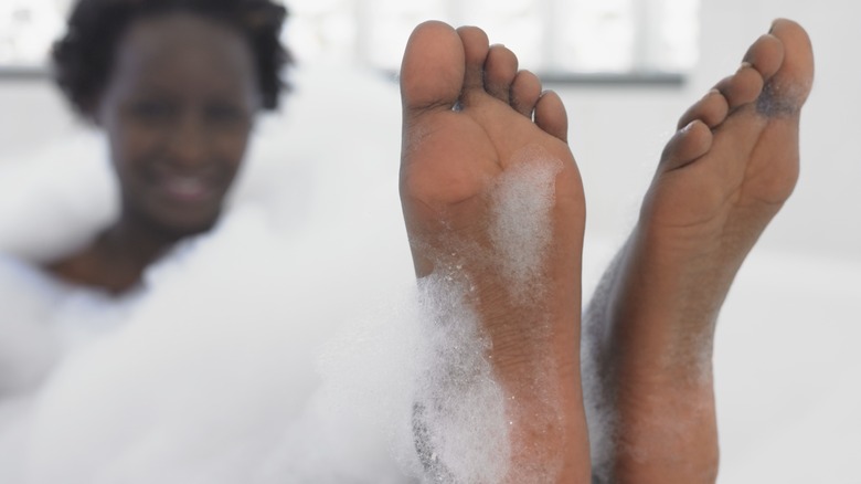 woman in bath washing feet