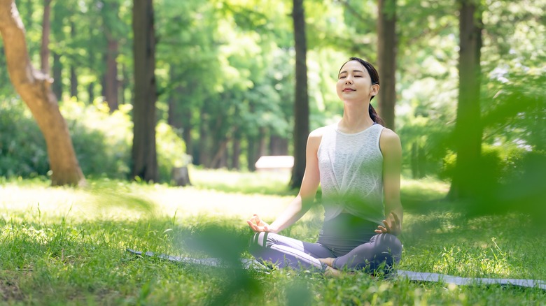 woman meditating in grass 