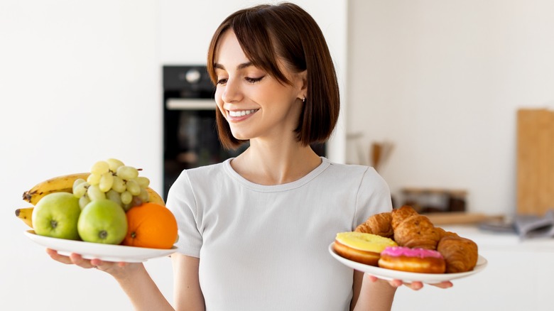 Woman carrying plates of donuts and fruits 