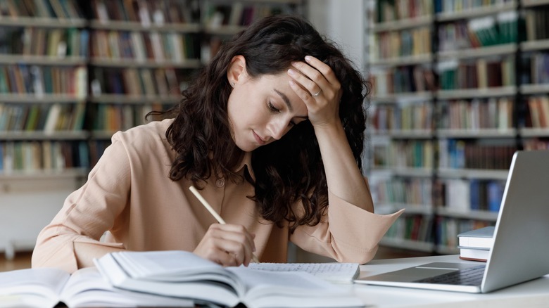 Stressed college woman studying 