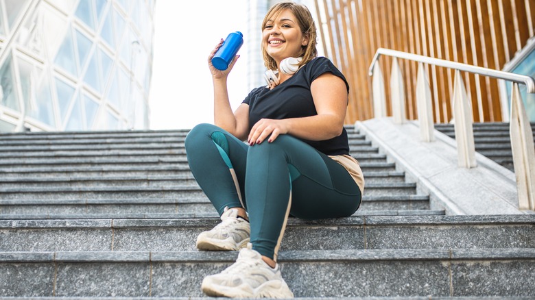 Woman drinking water during her workout 