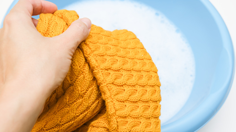 Hand washing a sweater in a bowl