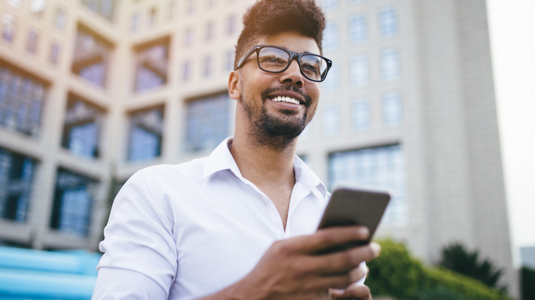 Smiling Black man holding phone