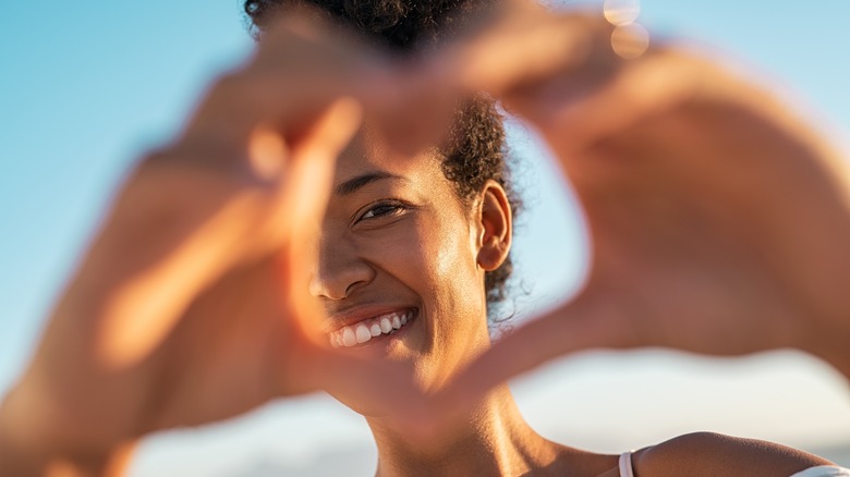 Black woman making heart hands