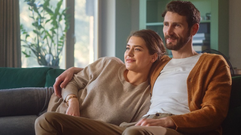 Couple lying into each other on couch