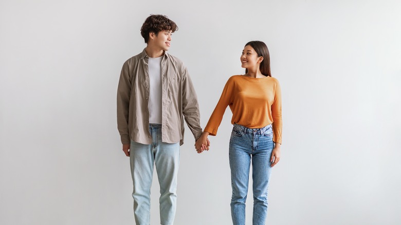 Couple holding hands while smiling at eachother