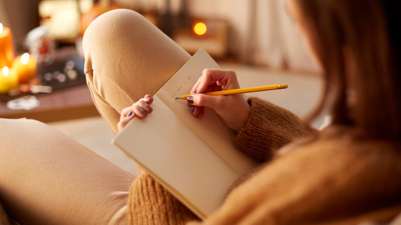 Woman writing down notes in a journal