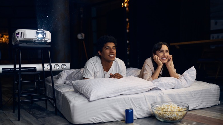 Couple watching film on projector together