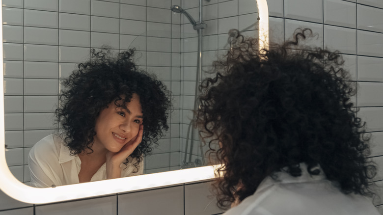 woman admiring self in mirror